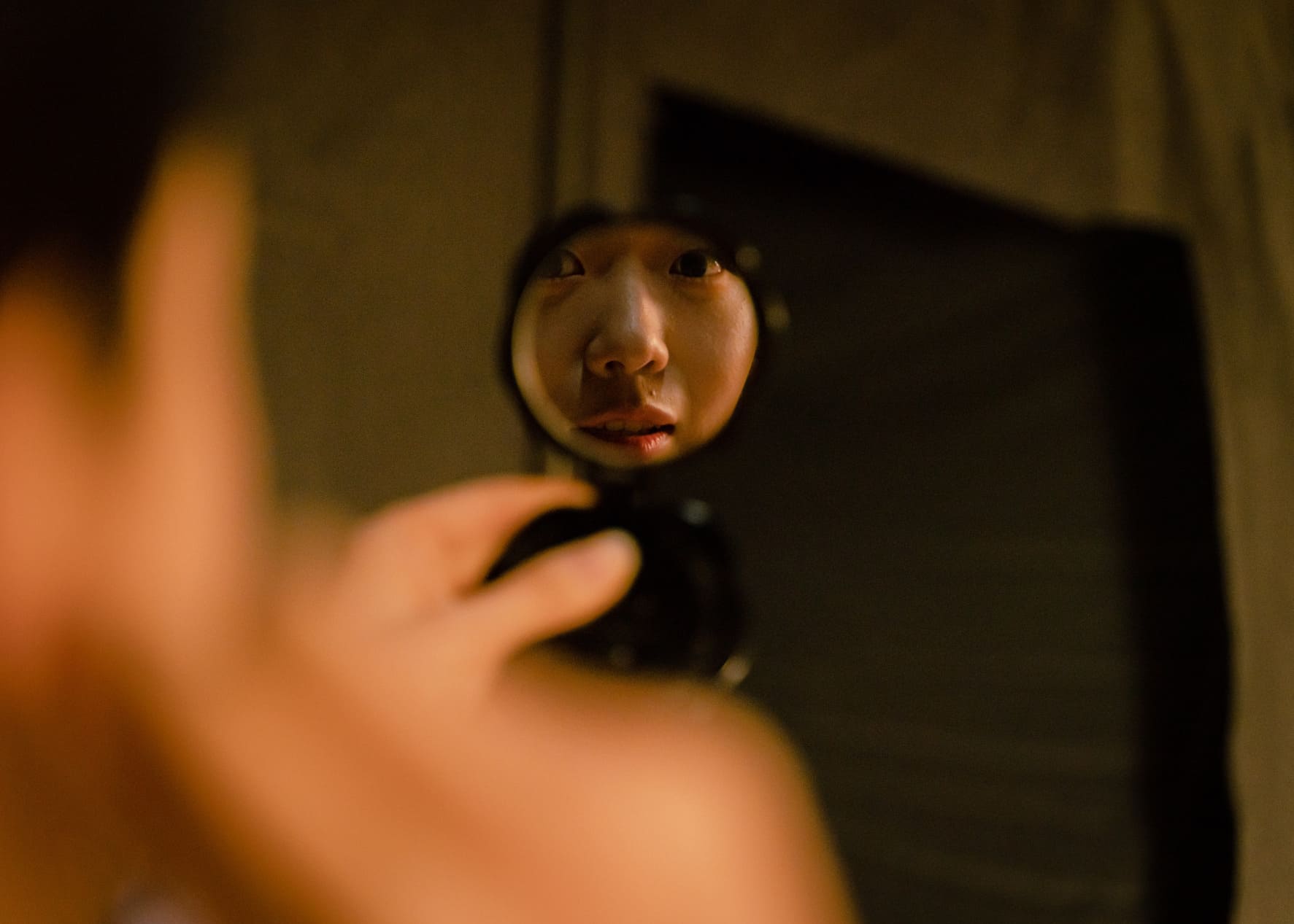 A girl is looking at mirror.